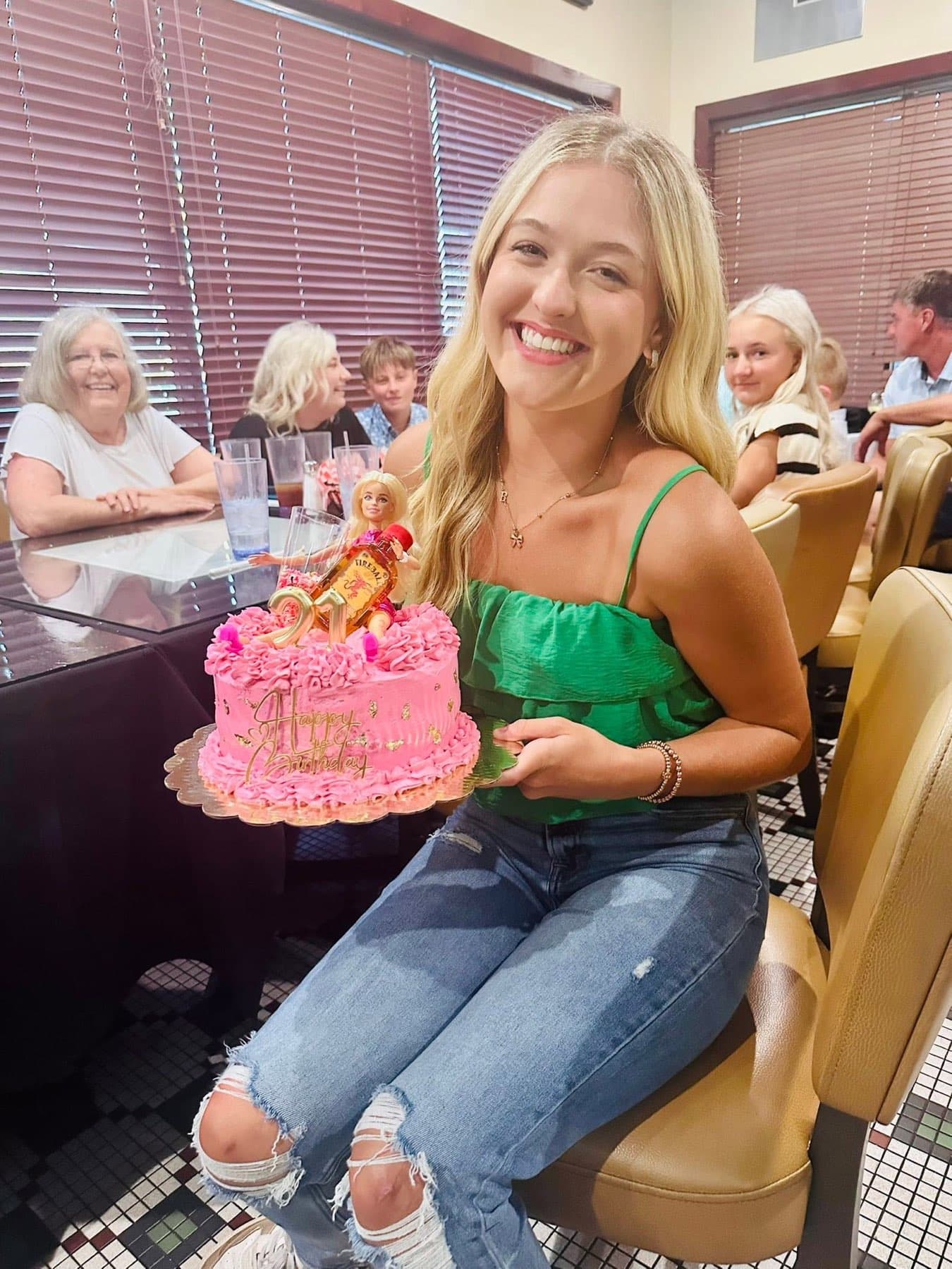 A guest celebrating a birthday with a pink cake