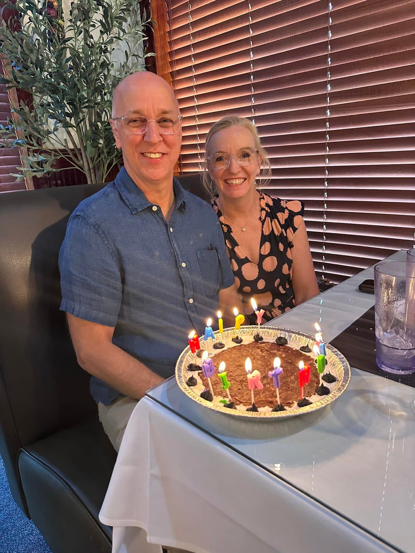 A couple celebrating with a birthday cake and candles