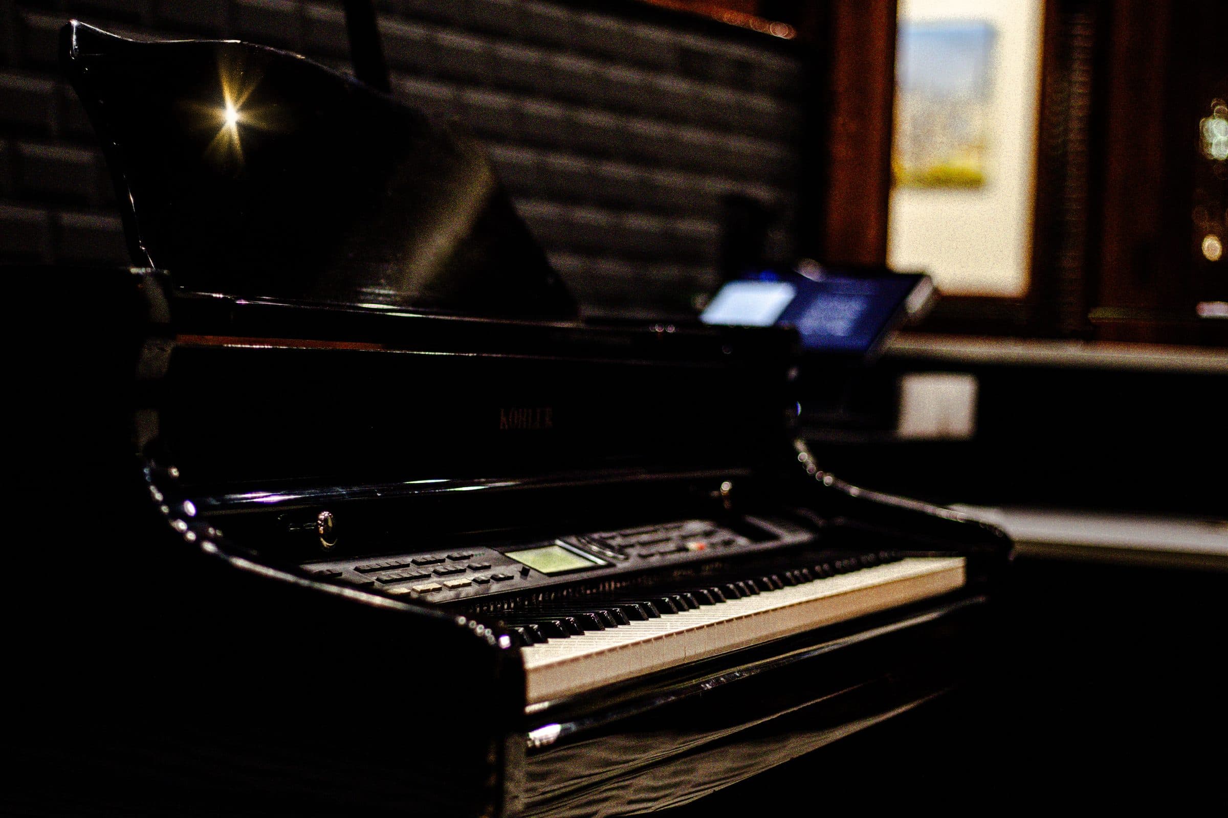 The grand piano in La Bocca's dining room under warm evening light